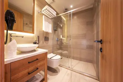 a bathroom with a toilet and a glass shower at Premier Lounge Hotel in Tuzla