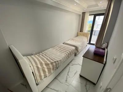 a bedroom with two beds and a table and a window at Ege Naz Villa in Avsa Adasi