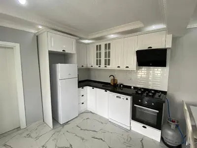 a kitchen with white cabinets and black appliances at Ege Naz 1 in Marmara