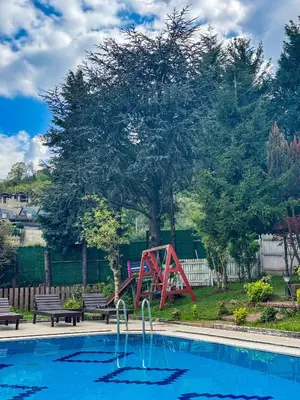 a red slide by a pool with a playground at Manzara Ödüllü Büyük Havuzlu Premium Villa in Dibektaş