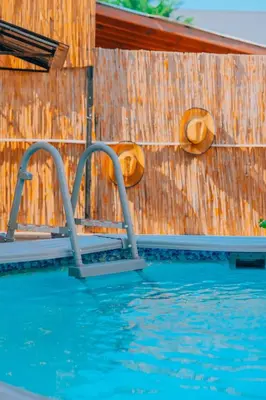 a swimming pool with two metal rails next to a wooden wall at Sapanca Villa Şen 2 in Sapanca