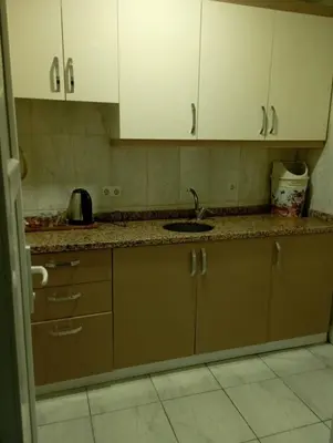 a kitchen with white cabinets and a sink at Rosse Hotel in Kırac