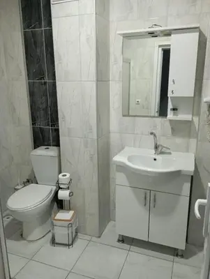 a white bathroom with a toilet and a sink at Rosse Hotel in Kırac