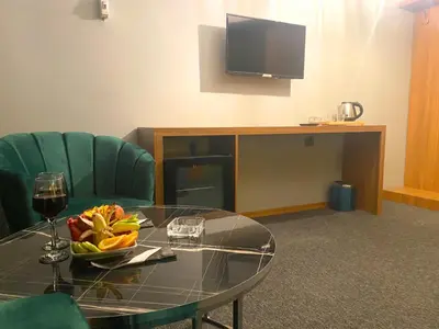 a table with a bowl of fruit and a television at Rosse Hotel in Kırac