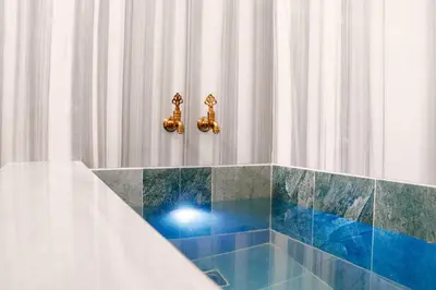 a bathroom with a shower with blue tiles at ivy Hotel Spa in Yalova