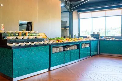 a kitchen with green counters with fruits and vegetables at ivy Hotel Spa in Yalova