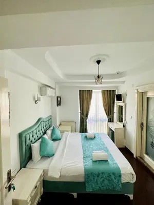 a bedroom with a large bed with blue pillows at LA MAİSON FAMILY Hotel in Istanbul