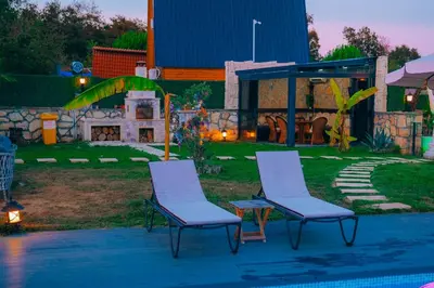 two chairs and a fireplace in a yard at MedaSuite Stone House with Detached Pool in Kandıra