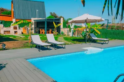 two chairs and an umbrella next to a swimming pool at MedaSuite Stone House with Detached Pool in Kandıra