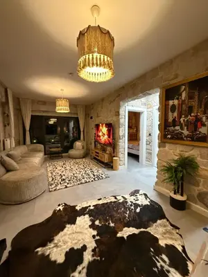 a large living room with a fireplace and a chandelier at MedaSuite Stone House with Detached Pool in Kandıra
