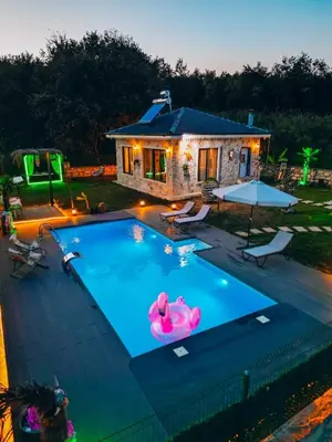 a swimming pool with a pink float in front of a house at MedaSuite Stone House with Detached Pool in Kandıra