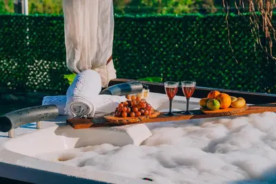 a table with two glasses of wine and fruit at MedaSuite Stone House with Detached Pool in Kandıra