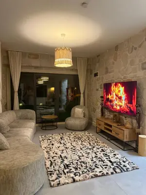 a living room with a fireplace and a tv at MedaSuite Stone House with Detached Pool in Kandıra