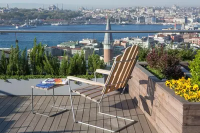 a chair on a balcony with a view of the city at Witt Istanbul Suites in Istanbul