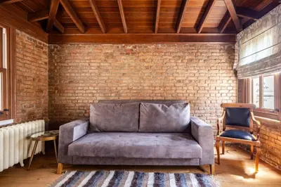 a living room with a couch and a brick wall at Chic 2BR Retreat House - Heart of Cihangir! #394 in Istanbul
