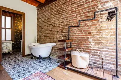 a bathroom with a brick wall and a bath tub at Chic 2BR Retreat House - Heart of Cihangir! #394 in Istanbul