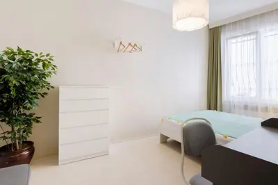 a white bedroom with a bed and a plant at Chic Apartment Walk to Maçka Park Nişantaşı in Istanbul