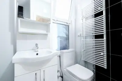 a white bathroom with a sink and a toilet at Chic Apartment Walk to Maçka Park Nişantaşı in Istanbul