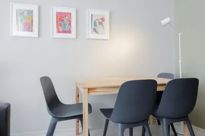 a dining room table with chairs and paintings on the wall at Chic Apartment Walk to Maçka Park Nişantaşı in Istanbul