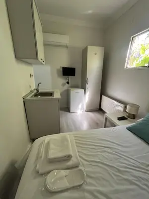 a bedroom with a bed with a sink and a refrigerator at Şişli Suites - Room23 in Istanbul