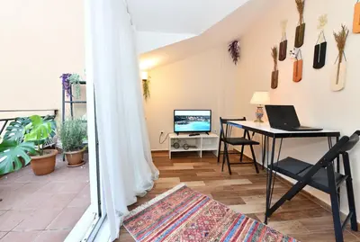 a living room with a table with a laptop on it at Private Terrace AC Bright Flat Galata in Istanbul