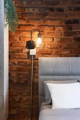 a lamp in a bedroom with a brick wall at Cute Retro Home Balcony AC Galata in Istanbul