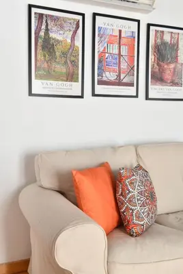 a white couch with four pictures on the wall at Cute Retro Home Balcony AC Galata in Istanbul