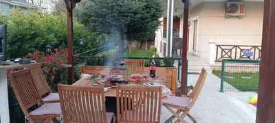 a wooden table with chairs and a bottle of wine at family villas sapanca in Sapanca