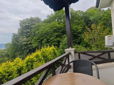 a table and chairs on a balcony with trees at family villas sapanca in Sapanca