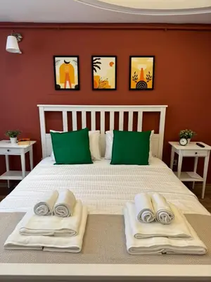 a bedroom with a large bed with towels on it at Heart of the City - Zey in Güzelce