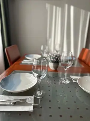 a table with three wine glasses and plates on it at Heart of the City - Zey in Güzelce