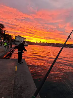 a man standing next to the water at sunset at An Istanbul tale, an Istanbul dream, garden house in Istanbul