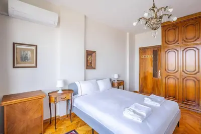 a bedroom with a white bed with a wooden cabinet at Spacious 4BR Home - Stunning Bosphorus Views! #390 in Istanbul