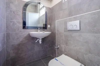 a bathroom with a sink and a toilet and a mirror at Spacious 4BR Home - Stunning Bosphorus Views! #390 in Istanbul