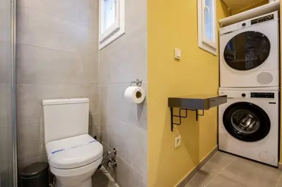 a bathroom with a toilet and a washing machine at Charming New 1BD Home - Close to Shoreline! #395 in Sarıyer