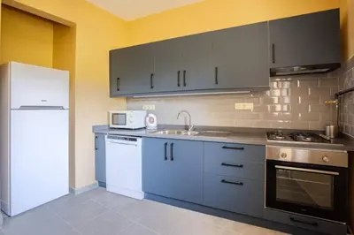 a kitchen with blue cabinets and a white refrigerator at Charming New 1BD Home - Close to Shoreline! #395 in Sarıyer