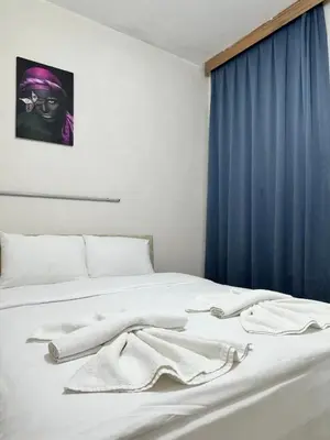 a bed with white sheets and a blue curtain at Apartment Taksim-Beyoğlu 2 in Istanbul