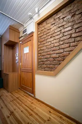 an office with a brick wall and a door at Mercan Apartments Balat - Mihrab Niche in Istanbul