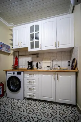 a kitchen with white cabinets and a washing machine at Mercan Apartments Balat - Mihrab Niche in Istanbul