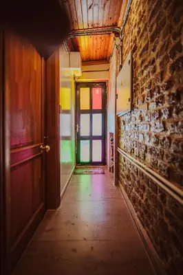 an empty hallway with a door and a brick wall at Mercan Apartments Balat - Mihrab Niche in Istanbul