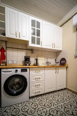 a kitchen with white cabinets and a washing machine at Mercan Apartments Balat - Mihrab Niche in Istanbul