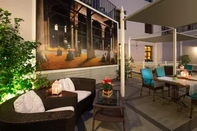 a patio with wicker furniture and a table and chairs at Lalahan Hotel in Istanbul