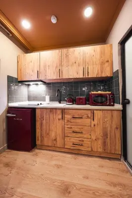 a kitchen with wooden cabinets and a red refrigerator at Tare Suites Beşiktaş in Istanbul