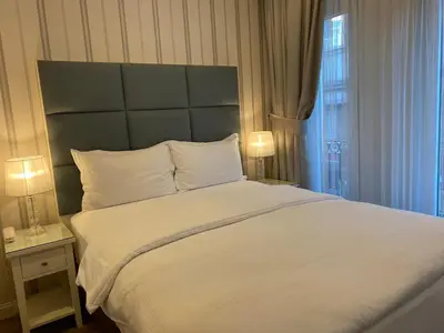 a bedroom with a large white bed with two lamps at T & R İstanbul hotel in Istanbul