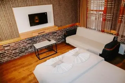 a living room with two beds and a tv at Pablo suit otel in Istanbul