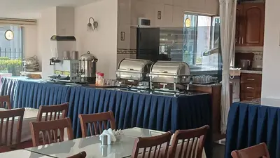 a restaurant with a table and chairs and a kitchen at Hotel Çağyiğit in Istanbul