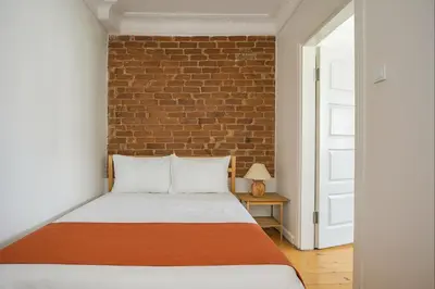a bed in a room with a brick wall at Istanberry - Joker Two Bedroom Apartments in Istanbul