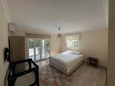 a bedroom with a white bed and a window at Sapanca Bizim Konak in Sapanca