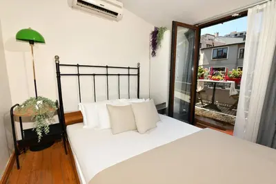 a bedroom with a white bed and a balcony at Cute Home Balcony Retro Design AC Galata in Istanbul