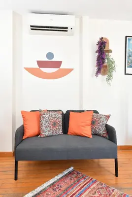 a couch in a living room with orange pillows at Cute Home Balcony Retro Design AC Galata in Istanbul